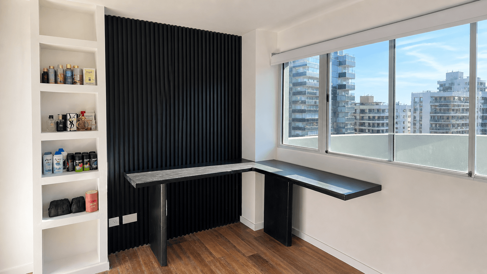 Revestimiento interior WPC negro instalado en pared de escritorio junto a una ventana