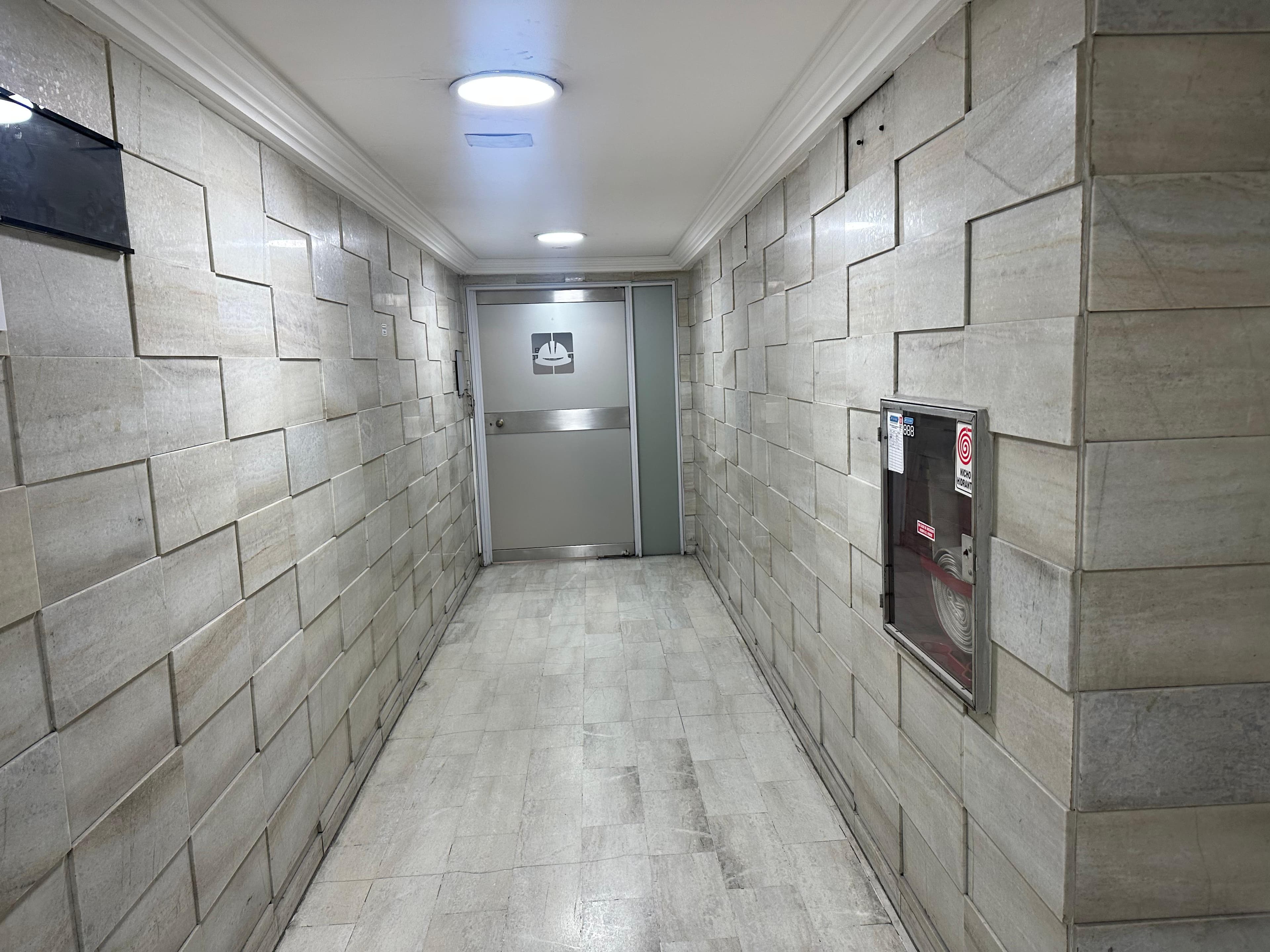 hall de un piso de un edificio en buenos aires antes de ser transformado por wall panels de wpc para interior varillado